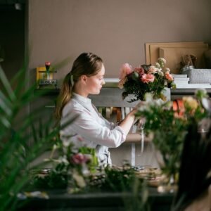 Female florist arranging fresh flowers in a small business setting.